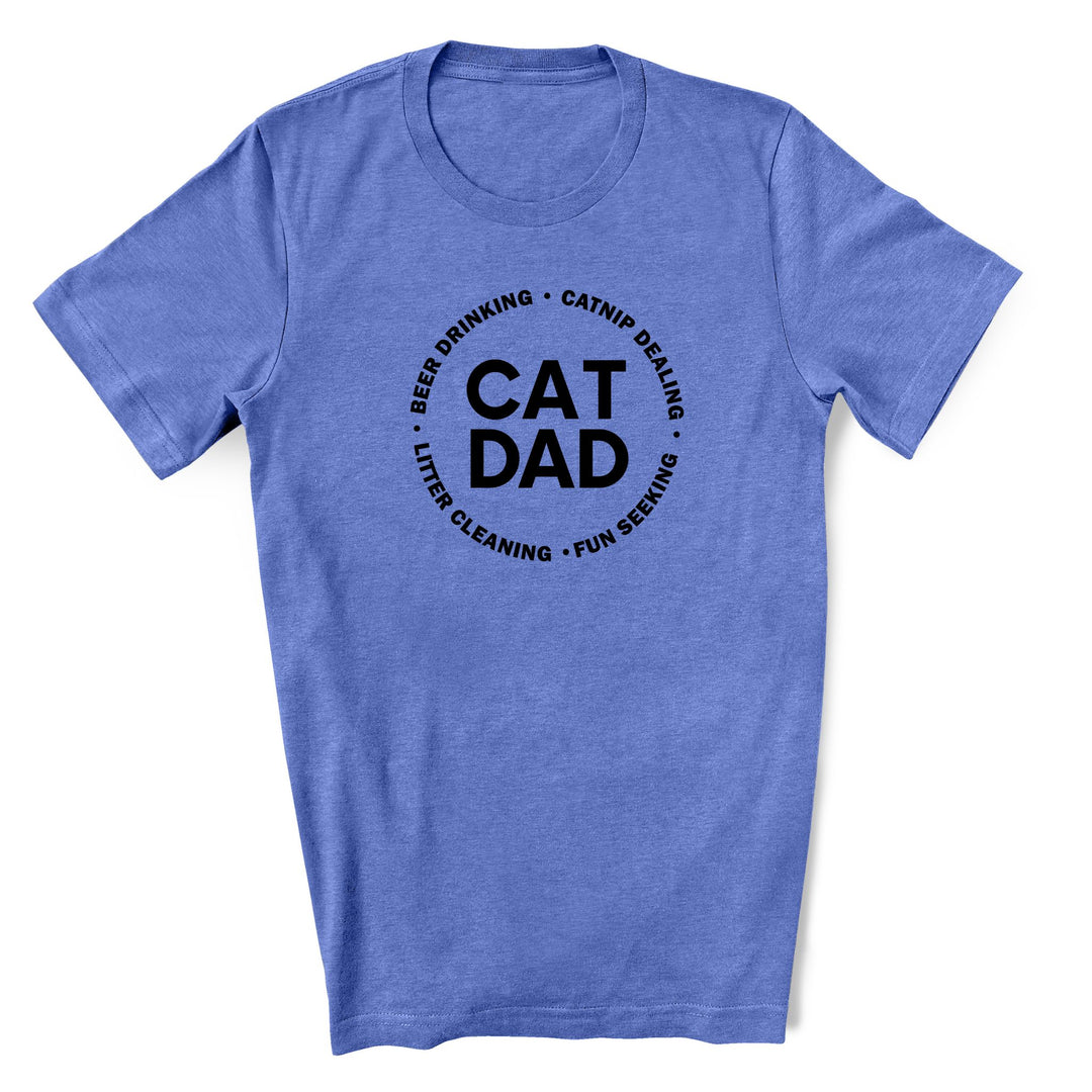 Cat Dad shirt in columbia blue. It has cat dad in the middle with beer drinking, catnip dealing, litter cleaning and fun seeking in a circle around it.