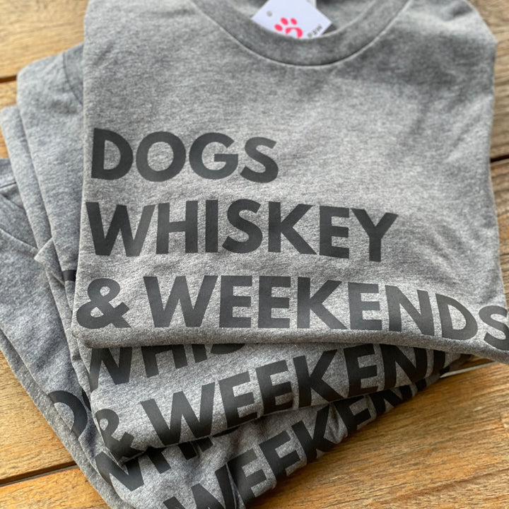 A stack of three gray t-shirts with dogs whiskey & weekends in black text