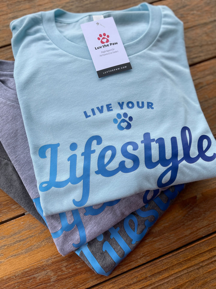 Flat lay of Live Your Lifestyle t-shirts in ice blue heather, athletic heather and deep heather