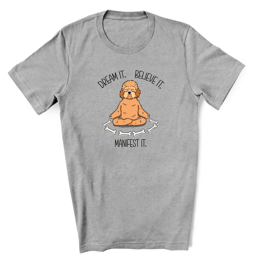 Gray t-shirt with a cute doodle dog meditating with the text Dream it. Believe it. Manifest it. 