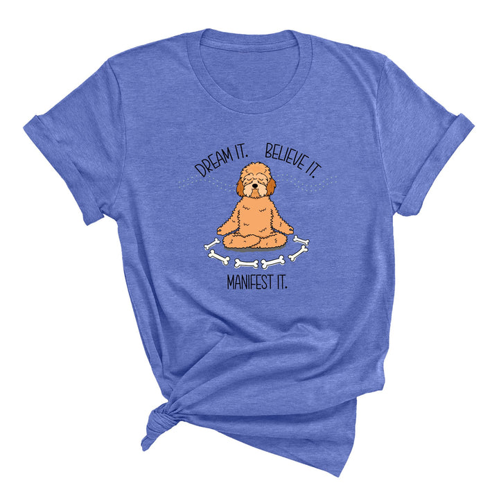 Blue t-shirt with a cute doodle dog meditating with the text Dream it. Believe it. Manifest it. 