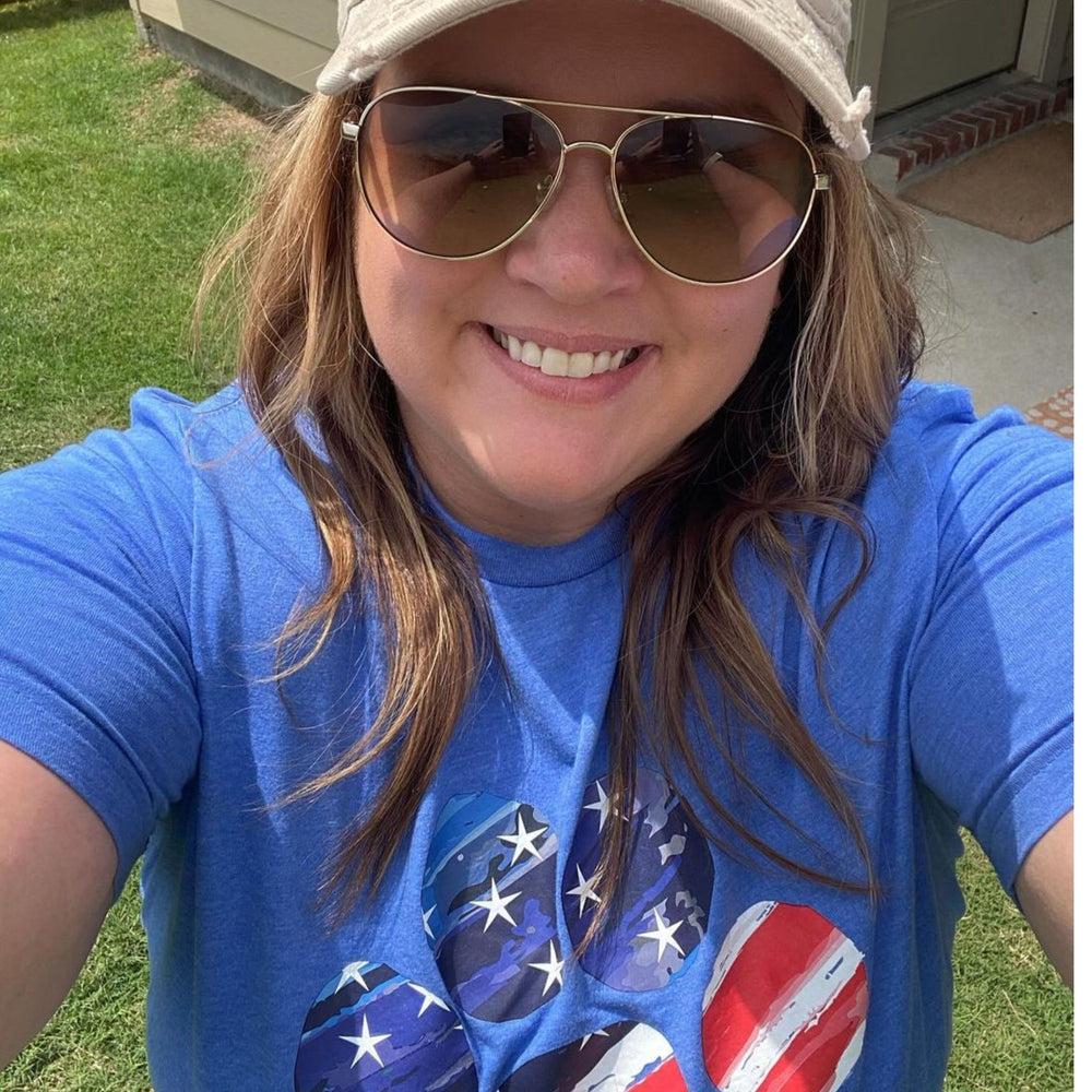 Female wearing a blue shirt with an American flag paw print