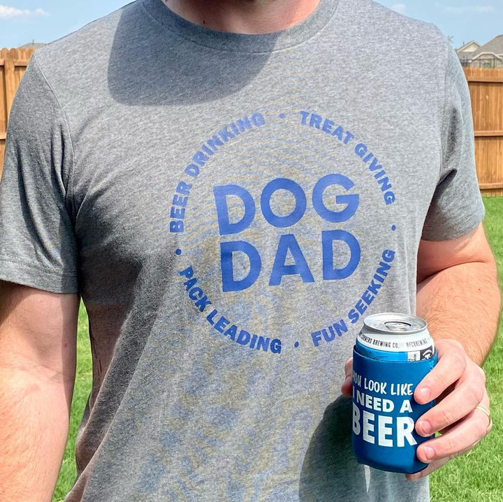 A man wearing a funny dog dad shirt made by Luv the Paw. He is holding a beer in his hand.