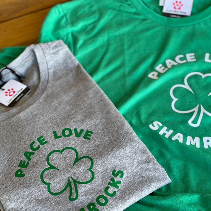 Grey and green t-shirt that has Peace Love and Shamrocks with a shamrock in the middle