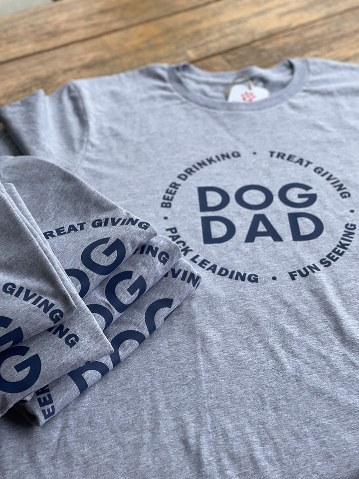 Folded Funny dog dad shirts featured in gray on a wooden table.
